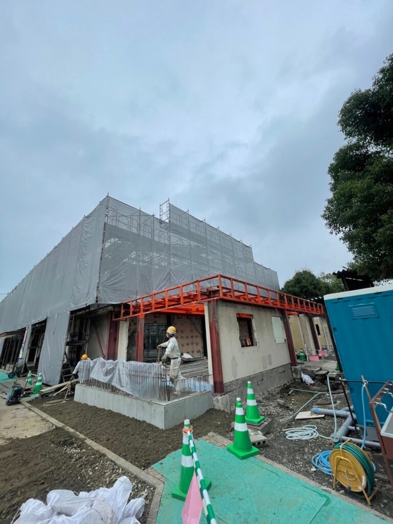 建設中の建物と工事現場で作業する人々