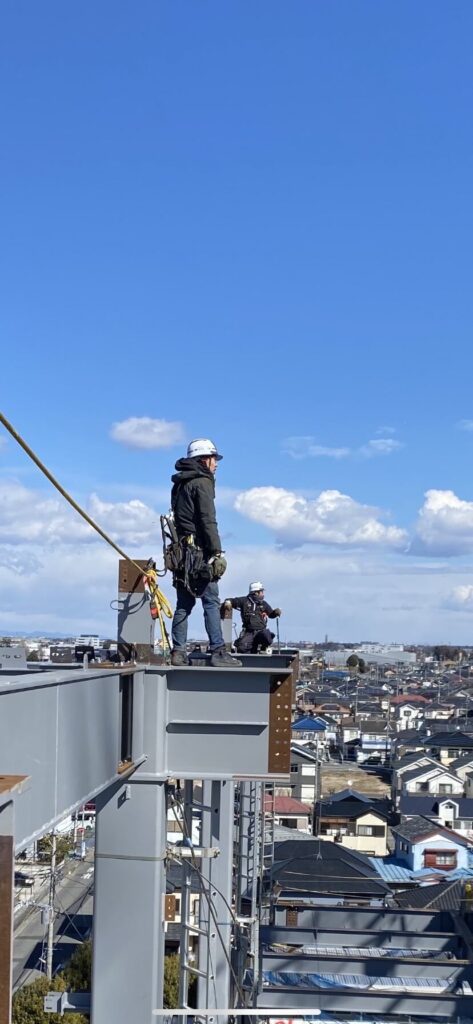 高所で鉄骨の上に立つ作業員たち